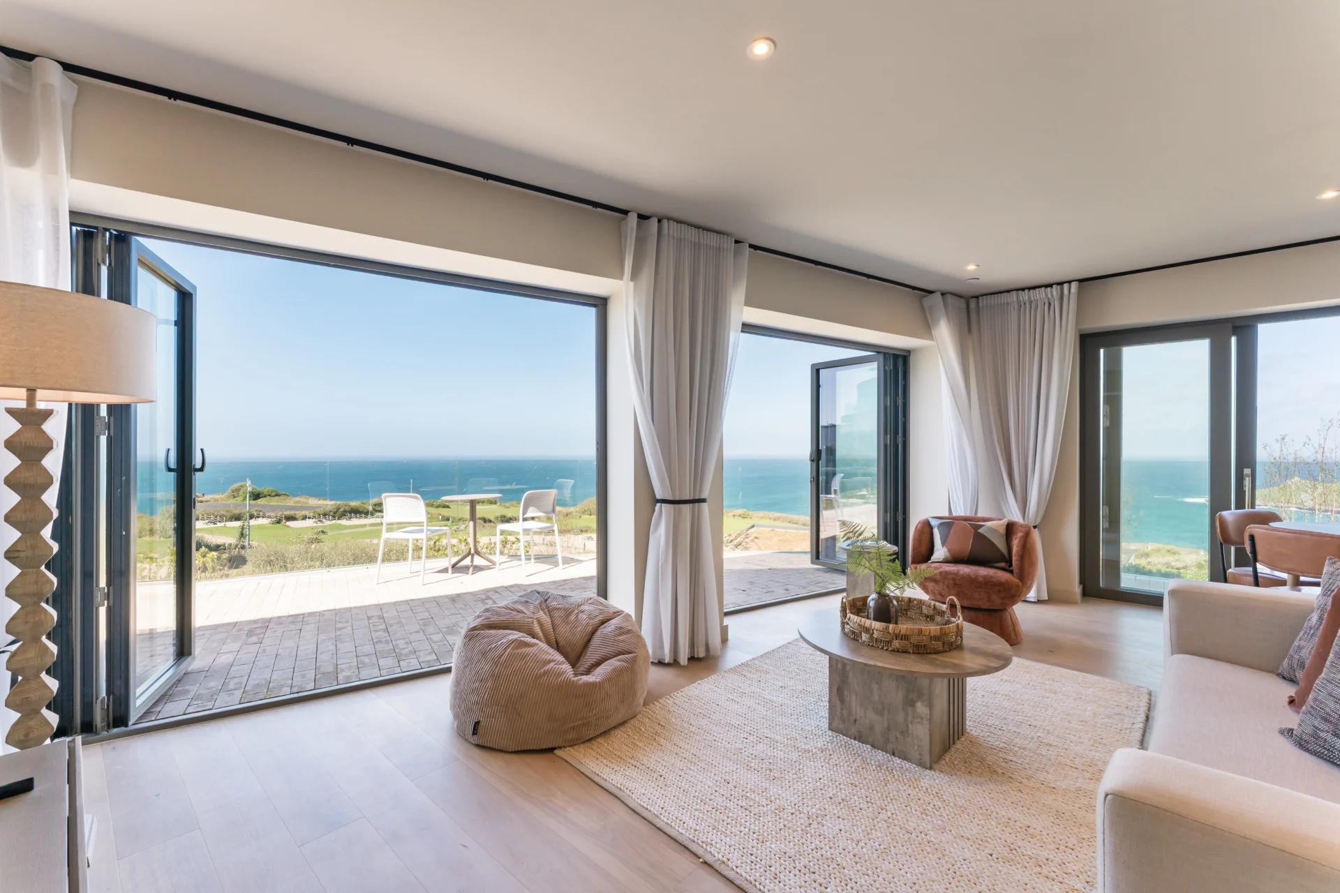 Coastal living room with ocean view through windows.
