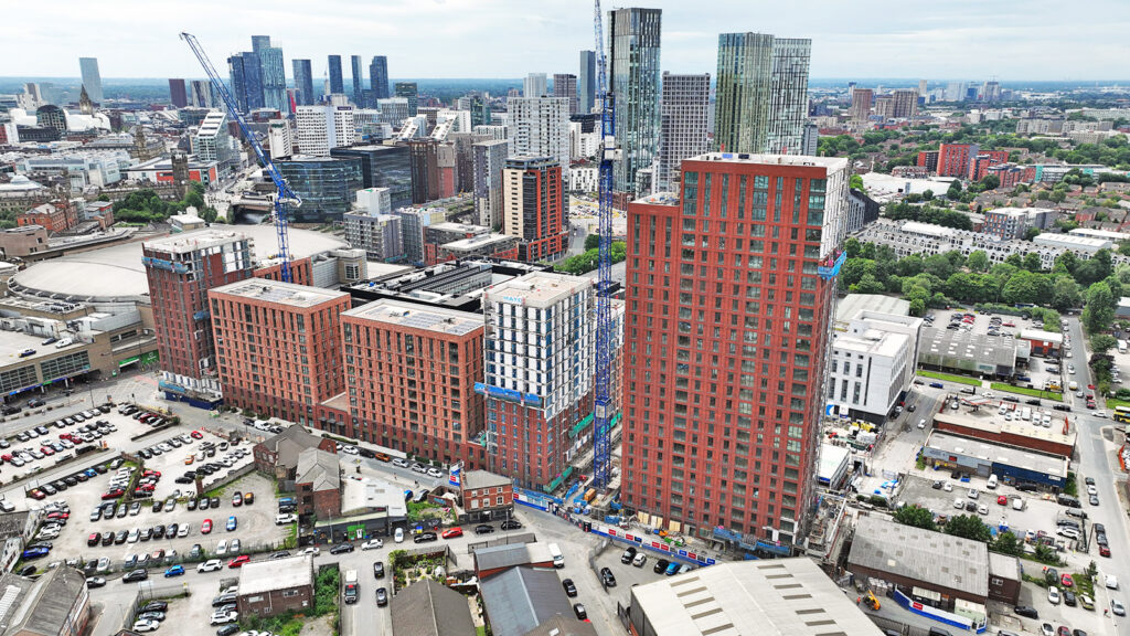 Aerial view of city skyscrapers and construction cranes.