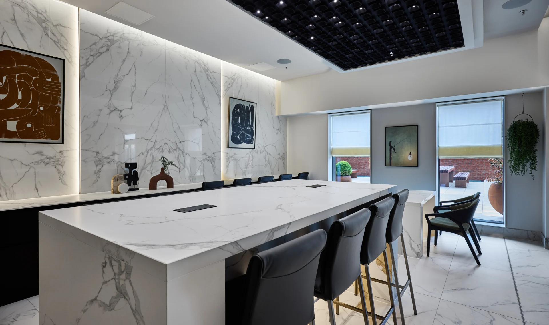 Modern kitchen with marble countertops and abstract art.