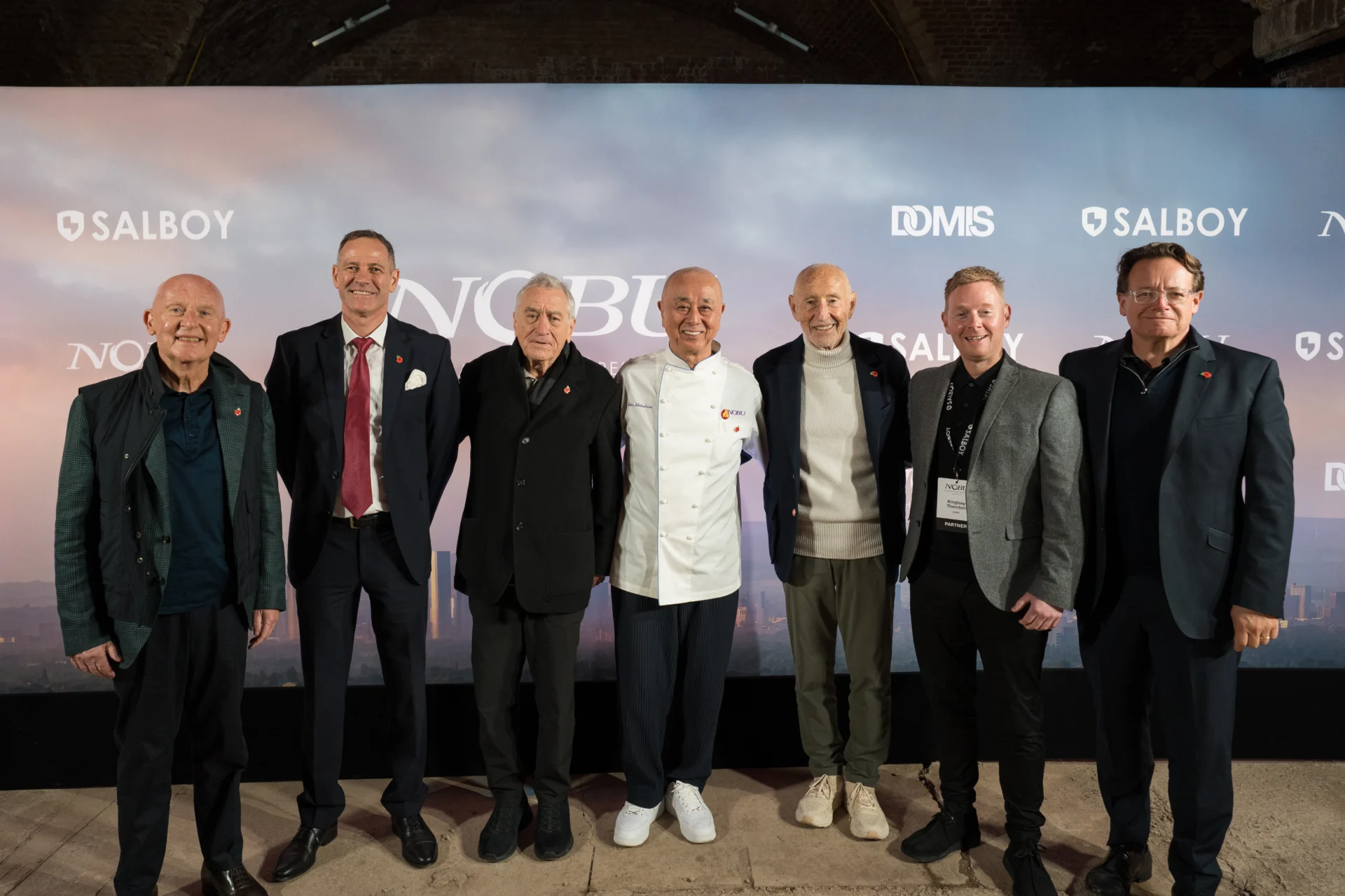 Seven men posing at a Nobu event