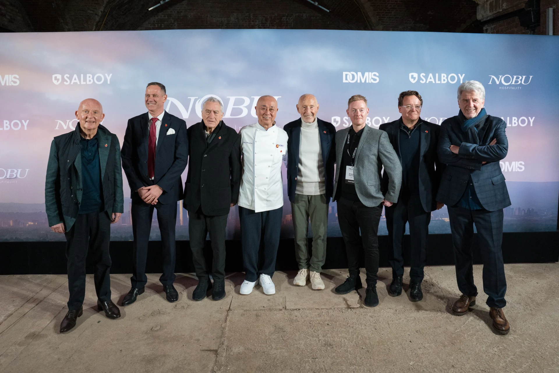 Group of men at Nobu event with backdrop.
