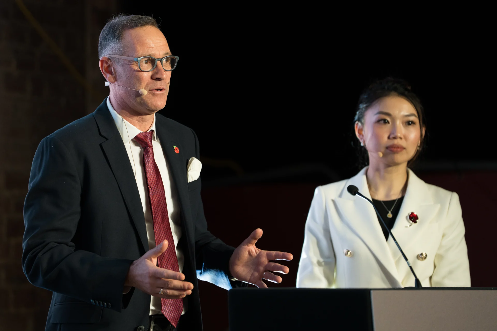 Two speakers presenting at a conference.