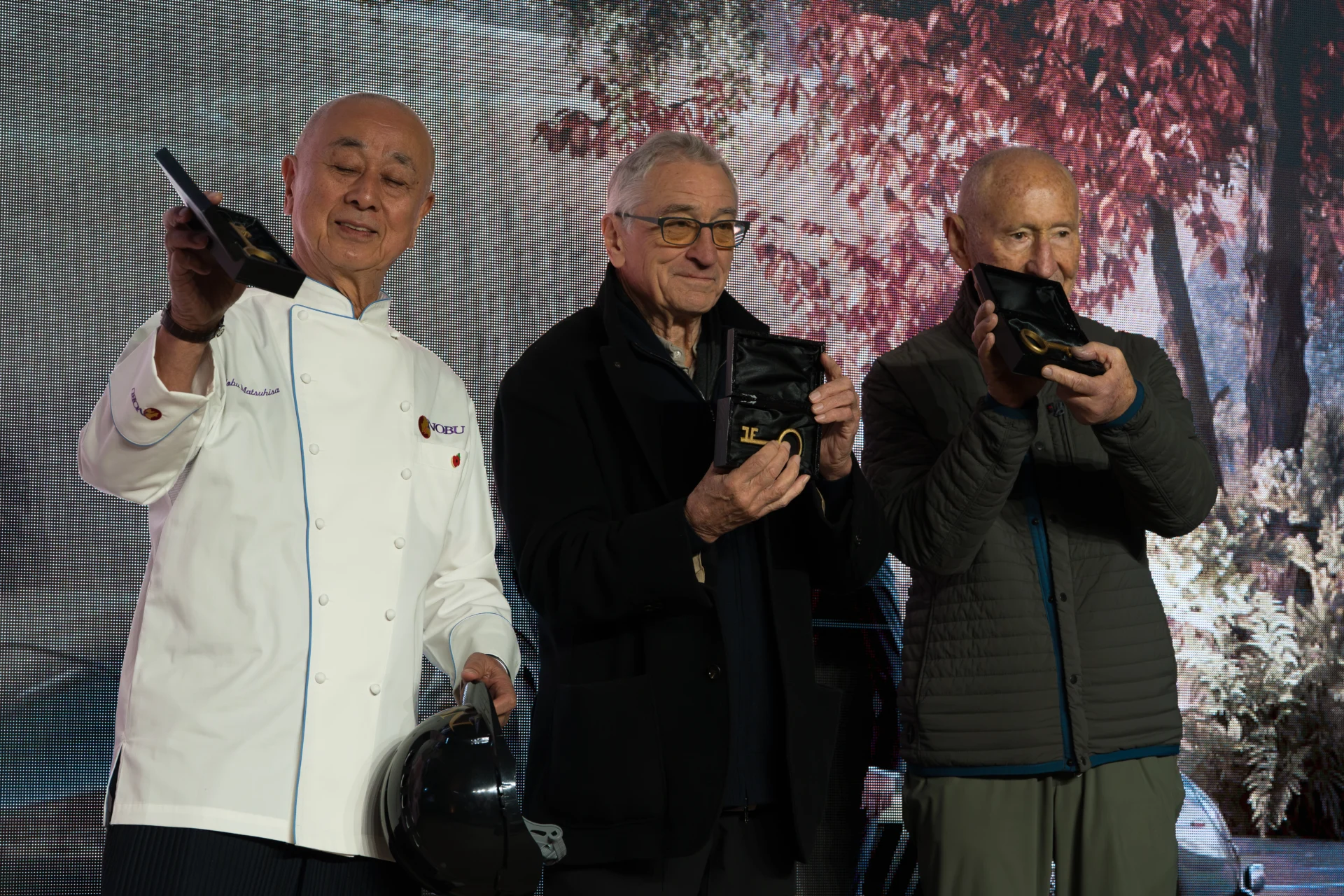 Three men holding awards at an event.