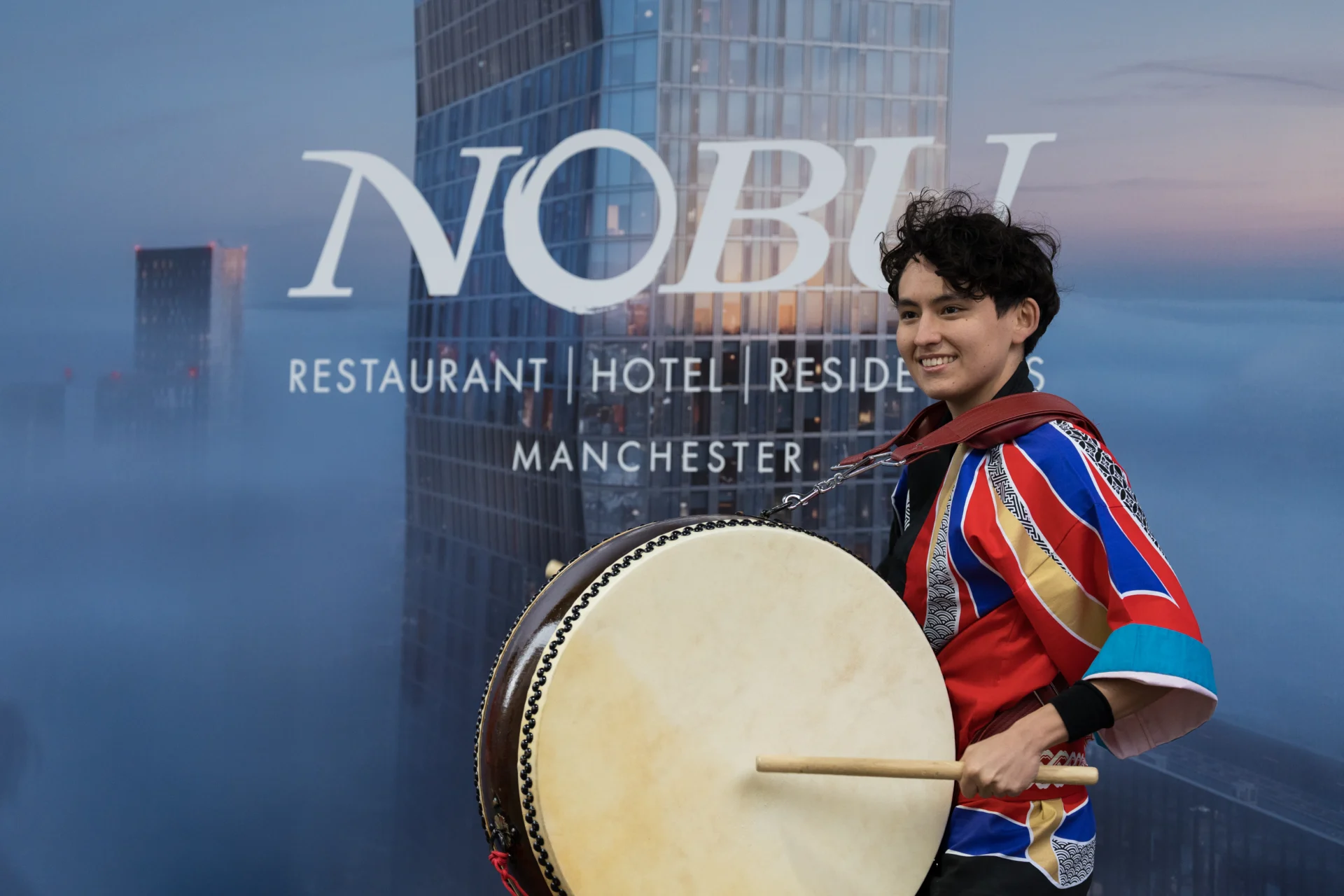 Drummer in colorful outfit at Nobu Manchester opening.
