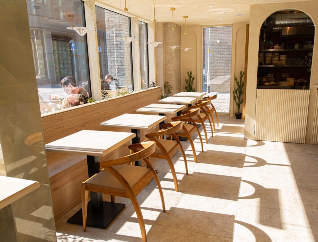 Sunny cafe interior with wooden tables and chairs.