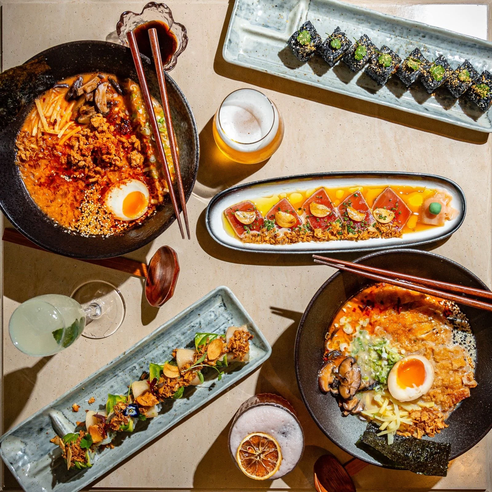 Assorted Japanese dishes: ramen, sushi, sashimi, and drinks.