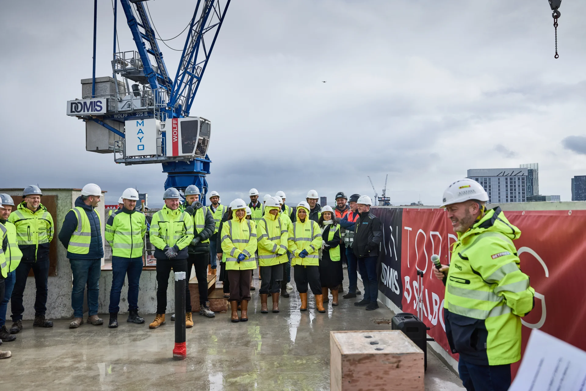 Construction team in safety gear at site event.
