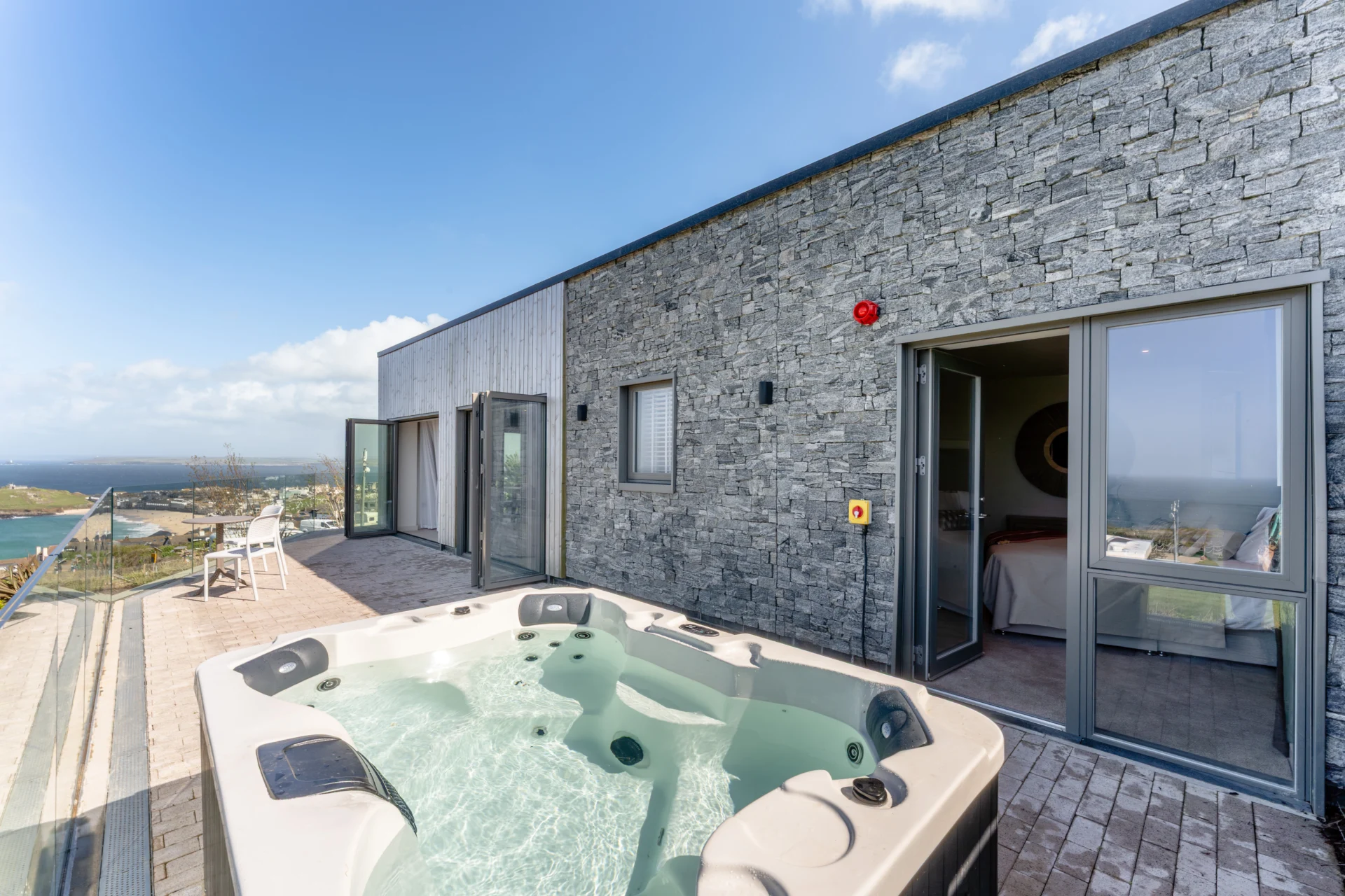 Luxury rooftop terrace with hot tub and ocean view.