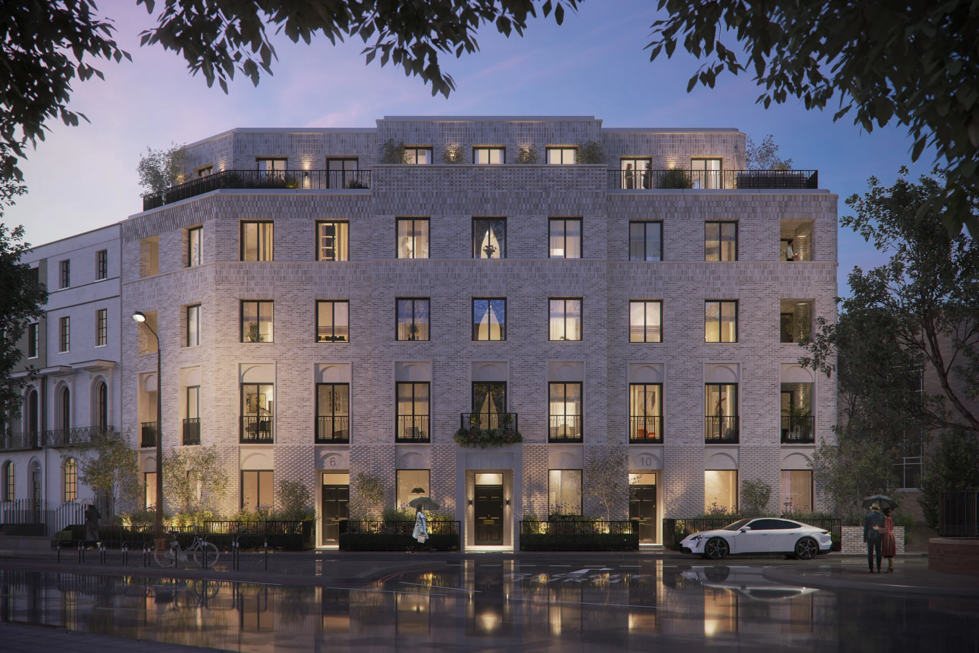 Modern apartment building at dusk with lights on.