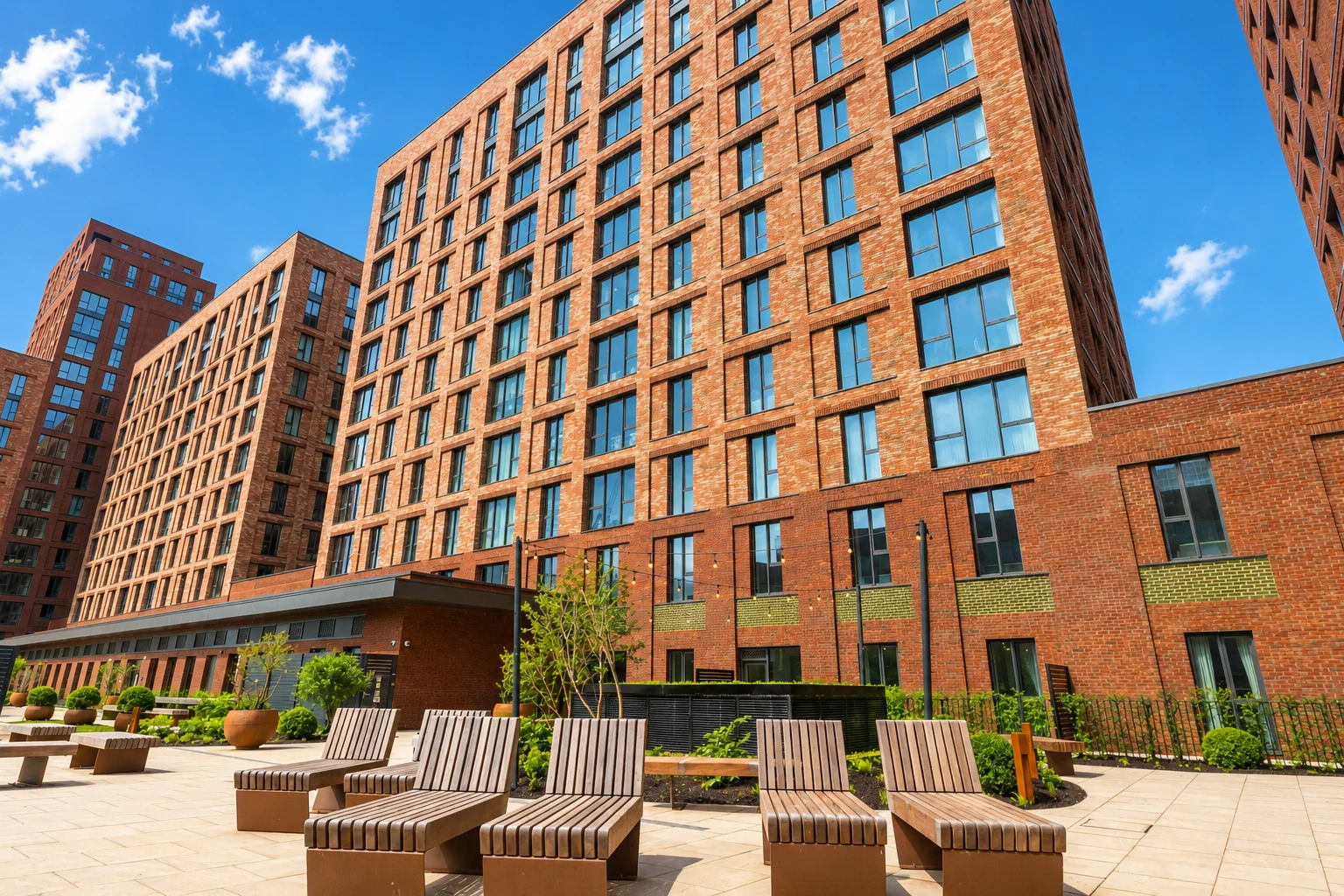 Modern brick apartment buildings with outdoor seating area.